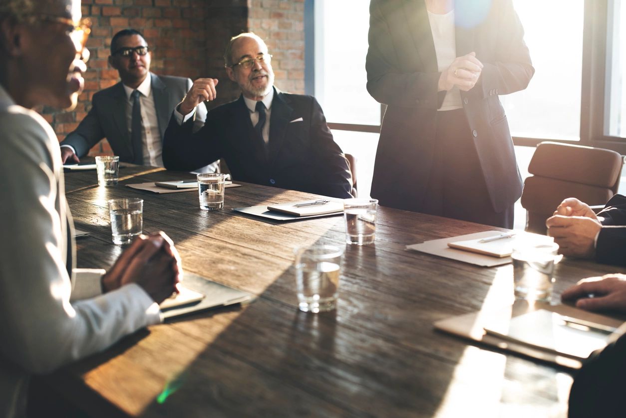 Boardroom meeting around wooden table