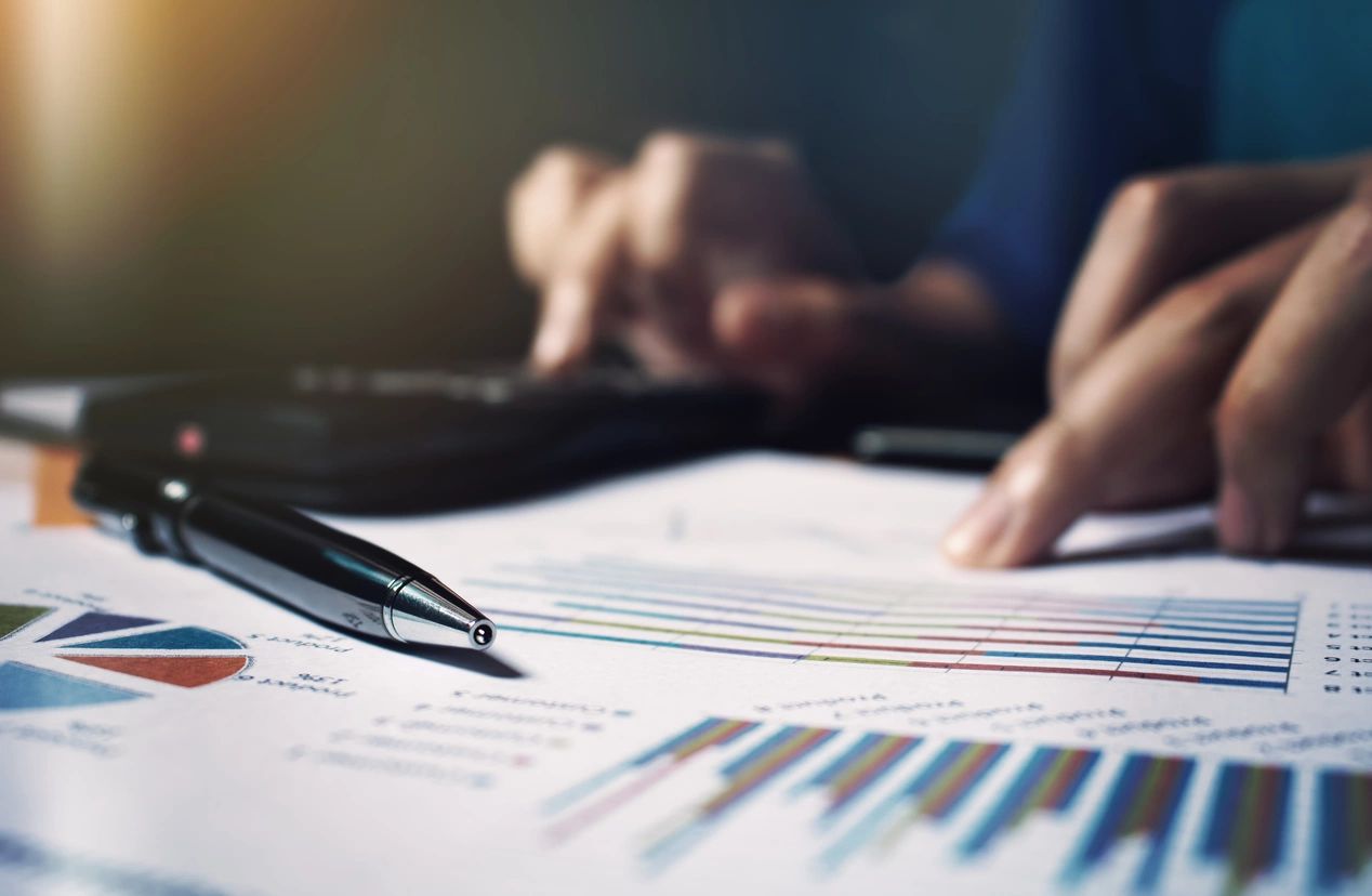 Pen on financial charts with calculator